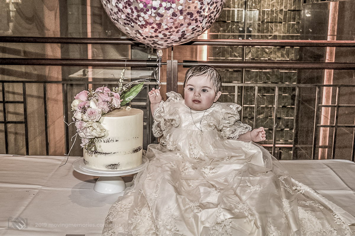 baby girl Valantia with her cake, balloon dressed in her Christening gown the Canterbury Leagues Club Sydney to celebrate her Greek Orthodox Christening