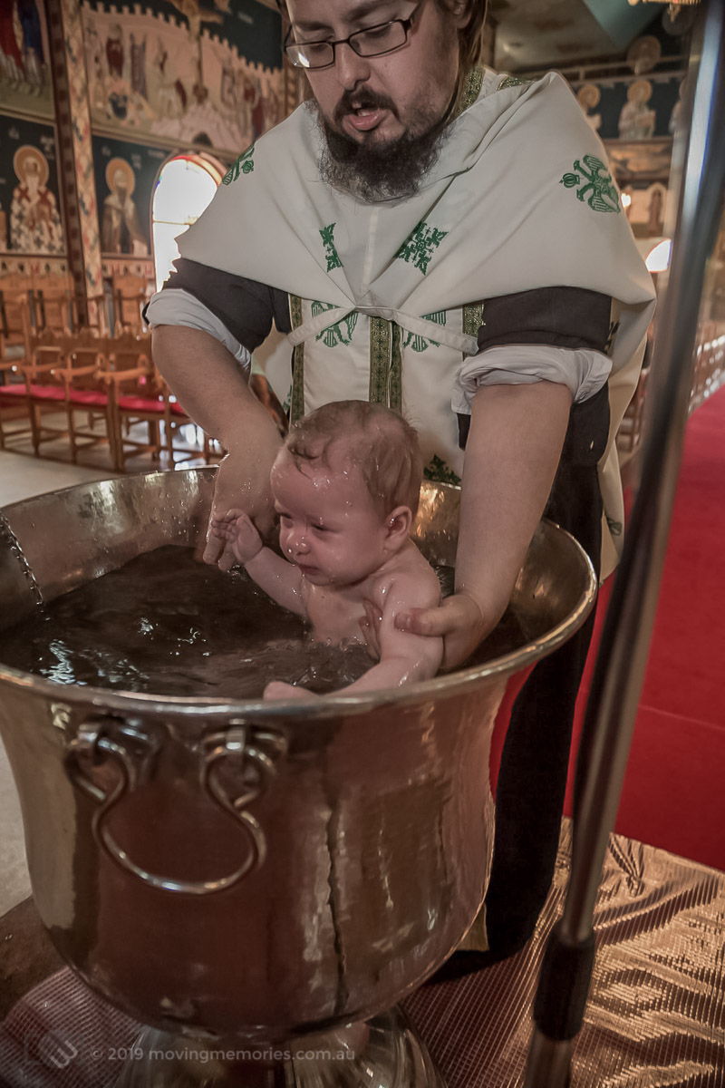 baby girl immersed in water at the baptism Sydney Greek Orthodox Christening Moving Memories Australia
