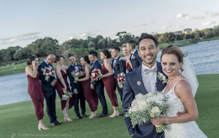 Sydney Groom Ermel, with his Bride Rachel, posing for a shot with their bridal party in the background by the lake at the Lakes Sydney