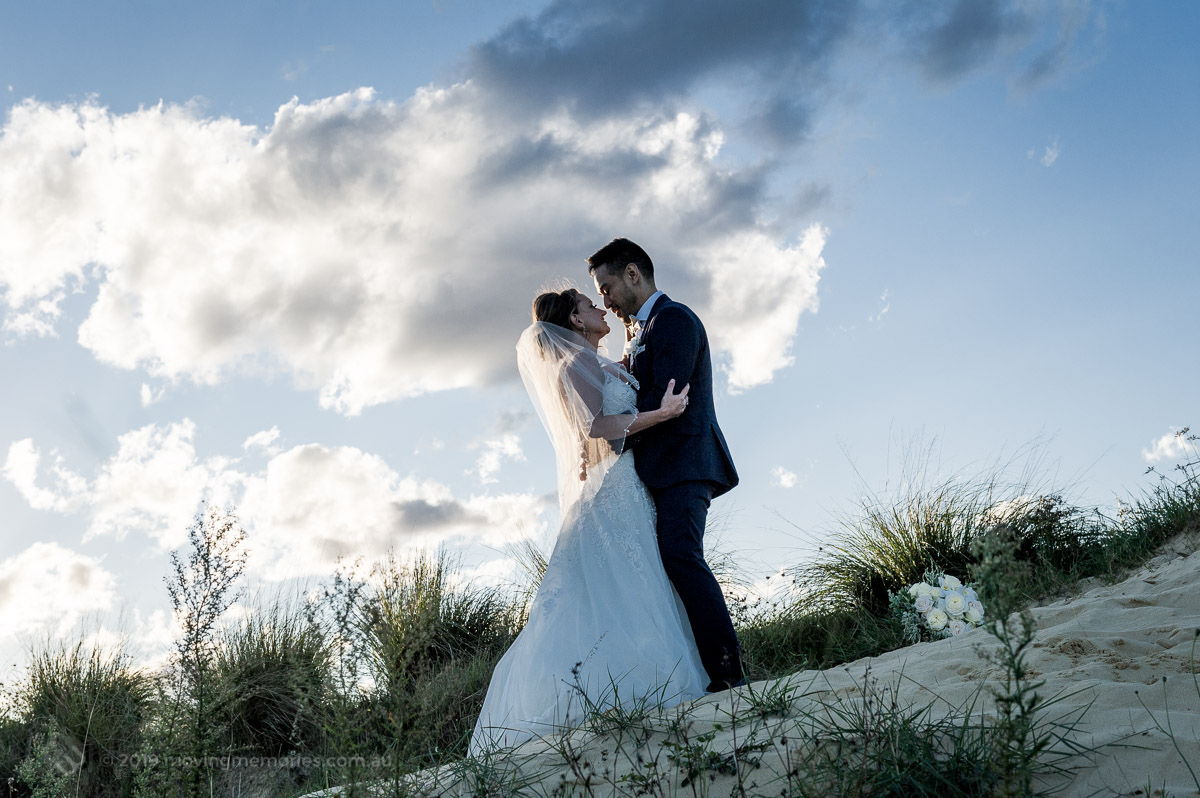 Sydney Bride and Groom embrace on the sand dunes at the Lakes Sydney